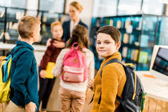男孩与背包看相机, 而参观图书馆与同学