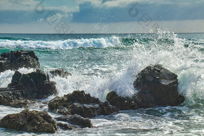 汹涌的海浪冲击着海岸的岩石图片-包图网企业站