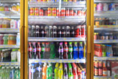 超市便利店冰箱架上装有软饮料瓶抽象模糊背景