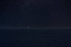星夜浩瀚中的海上帆船