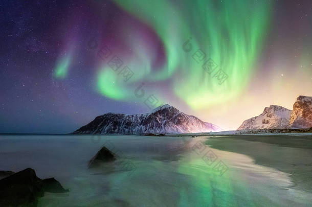 挪威洛福敦群岛上的北极光。山和海滩上方的绿色北极光。<strong>夜晚</strong>的天空与极光。夜冬天<strong>风景</strong>与极光。挪威的自然背景