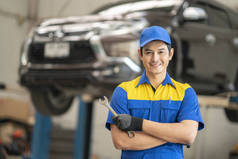 亚洲人在汽车维修、保养和人的概念，快乐的笑着的汽车修理工或车工与剪贴板在车间