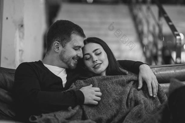 在<strong>浪漫</strong>的咖啡馆里，可爱的女孩和她的男朋友拥抱坐在毯子下的坐在的毯子里。黑白<strong>照片</strong>