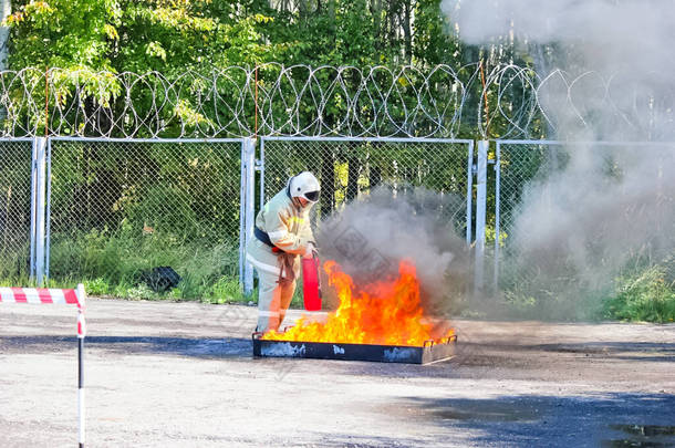 俄罗斯莫斯科- 2018年8月25日：使用灭火器灭火，用石油产品燃烧槽.