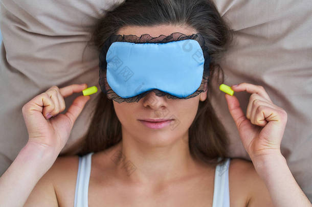 睡梦中女性使用护目镜和耳塞，以改善睡眠、保护噪音和美梦