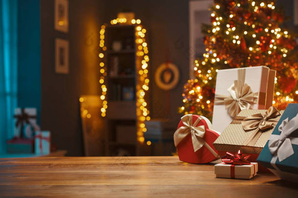 家中桌上<strong>摆放</strong>着精美的圣诞礼物，树上点缀着灯光，还有节日和节日的概念