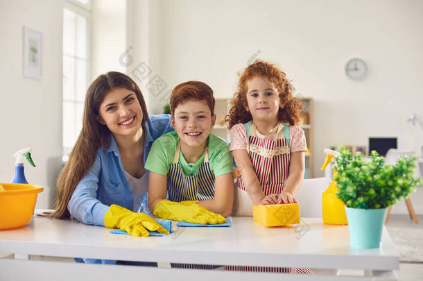 有<strong>妈妈</strong>和两个孩子在家里打扫卫生的快乐家庭。父母和孩子一起在室内<strong>做家务</strong>活