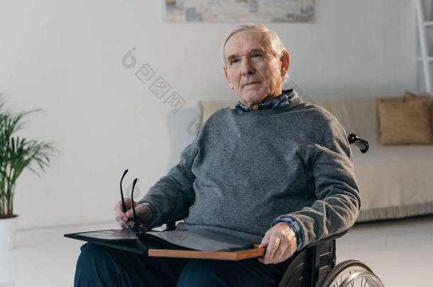 轮椅老人手持旧相册