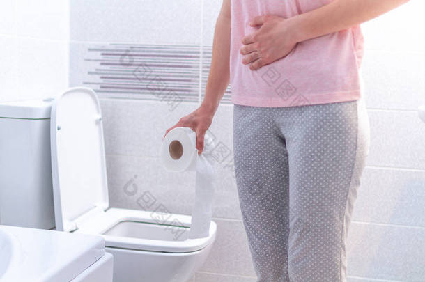 拿着纸卷的妇女在厕所里患有<strong>腹泻</strong>、便秘和膀胱炎。 Pms期间胃痛和腹部疼痛。 保健服务