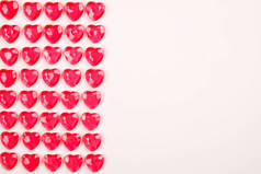 红桃红色的心糖果在白色背景下排成一行。情人节贺卡礼品.