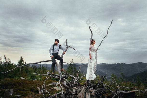 男人和女人站在枯木上