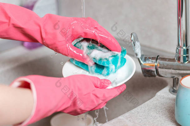 干家务活一个戴粉色橡胶手套的女人在洗碗.关闭<strong>厨房水池</strong>和双手.