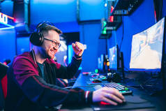 专业游戏玩家使用红色和蓝色耳机在网上玩电子游戏