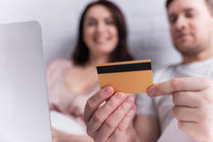 男人和妻子手握信用卡，背景模糊