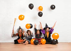 在万圣节假期玩气球的吸血鬼和女巫的服装朋友组