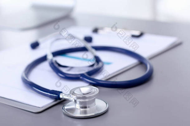 医疗设备：蓝色听诊器和白色背景的平板。医疗设备
