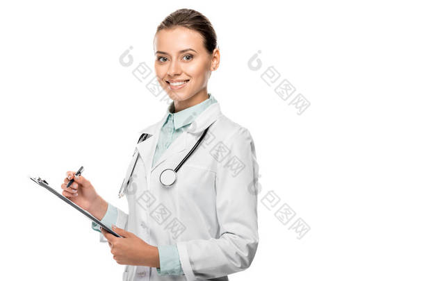 微笑的年轻女医生在医疗<strong>大衣</strong>写在剪贴板上的白色隔离