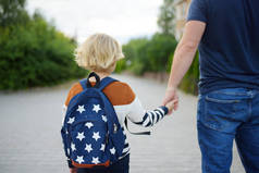 暑假后，小男孩和他的父亲一起去上学。为幼儿提供教育。儿童的教育。回到学校的概念.