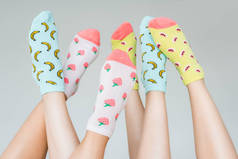 彩色果味袜中女性脚的部分视图, 灰色隔离