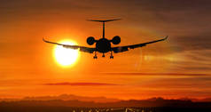 飞机剪影在日落时降落在机场。太阳, 私人喷气飞机的形状和闪烁的跑道灯.