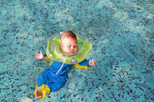 新出生的泳衣漂浮在<strong>游泳池</strong>与安全的<strong>婴儿</strong>脖子浮动.