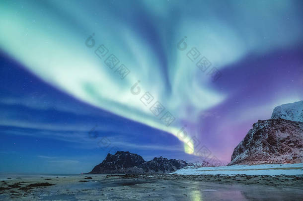 罗弗敦群岛上的北极极光, 挪威。山上的绿色北极光。夜空中的极<strong>地灯</strong>光。夜间冬季景观与极光和倒影在水面上。自然背景在挪威