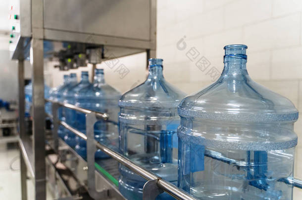 纯水生产厂输送带机械设备上的空塑料瓶或加仑