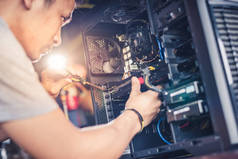 技术员拿着螺丝刀修理电脑。计算机硬件、维修、升级和技术的概念.