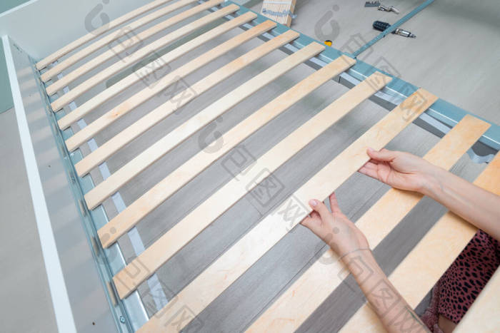 女手组装机架和小齿轮木制床座为床垫和脊椎图片-包图网企业站