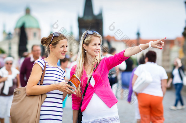 两名<strong>女性游客</strong>沿着同时观光在布拉格查理大桥走