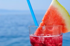 新鲜热带水果鸡尾酒用水甜瓜片在海滩上