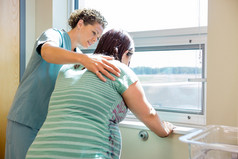 护士安慰紧张孕妇在医院病房的窗口