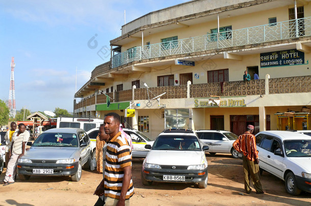 2008 年 11 月 27 日埃塞俄比亚-莫耶尔： 埃塞俄比亚和肯尼亚之间的边界上的村落。酒店的特写镜头。车停在酒店前面的汽车。不熟悉的村民们走自己的事.