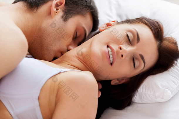 美丽年轻恩爱的夫妻躺在床上做爱