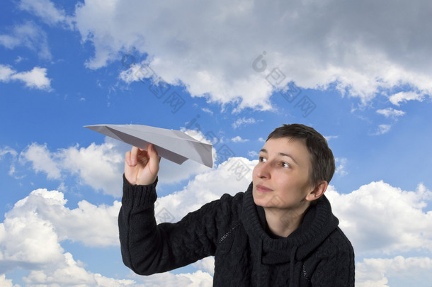 年轻<strong>的</strong>白人女孩开始纸飞机在<strong>湛蓝的天空</strong>