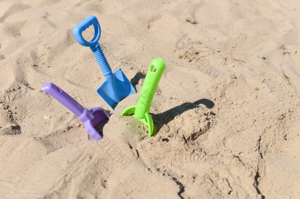 蓝色、 绿色、 紫色<strong>沙滩</strong>铲被困在<strong>沙滩</strong>上<strong>阳光</strong>明媚