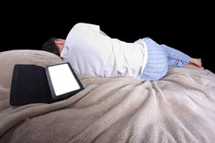 男性在平板电脑上阅读前入睡