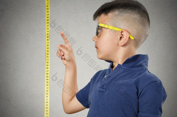 孩子指着他的身高上卷尺