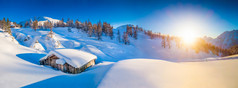冬季景观在阿尔卑斯在夕阳与旧的山间小屋