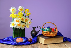 彩色复活节彩蛋、 书籍和花瓶中的花