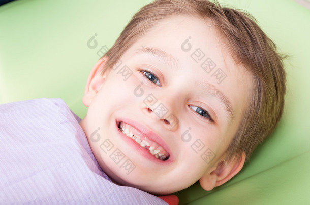 Smiling child with <strong>happy</strong> face on dentist chair or office