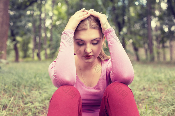 portrait stressed sad young woman sitting outdoors on summer day in park