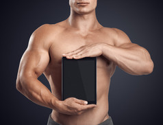 健身男性持有与空白屏幕垂直数字平板电脑