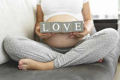孕妇拿块以使爱单词的字母