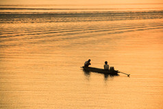 渔民与黄色及橙色背景的剪影