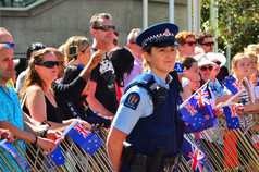 New Zealand police officer woman guarding crowd of people