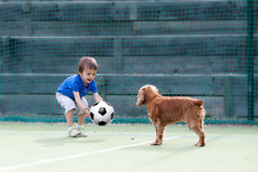 可爱的小男孩，和他的狗踢足球
