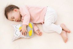睡觉和做梦在床上的猫头鹰玩具漂亮宝贝女孩蹒跚学步