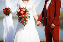 在巴勒莫颜色风格的婚礼。新娘和新郎手牵着手在祭坛上.
