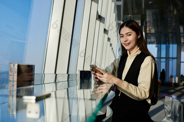 女性使用电话，而坐在空间与当代内部